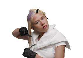 Stylist spreading toner evenly from roots to tips on blonde hair